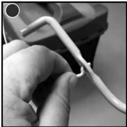 Close-up of a hand holding a white wire with a loop, partially visible in the background (no text or symbols)