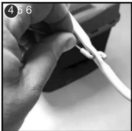 Close-up of a hand holding a white tool, no visible text or symbols