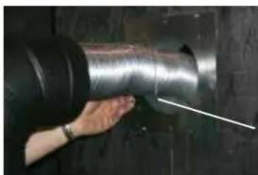 Close-up of a hand holding a large metallic pipe with a white line indicating a measurement or inspection (no text or symbols visible)
