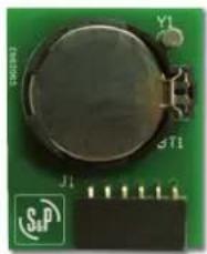 Close-up of a green electronic circuit board with a circular component and terminal blocks (no readable text or symbols)