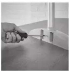 Close-up of a hand using a screwdriver to apply a component on a surface (no text or symbols visible)
