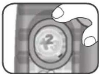 Close-up of a hand holding a circular object with a number '2' on its surface (no readable text or symbols)