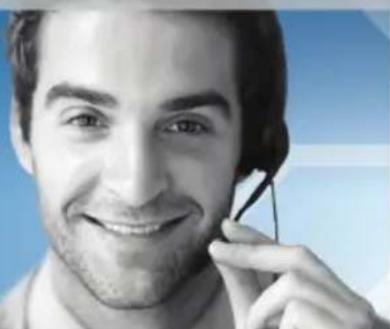 Close-up portrait of a smiling man holding a headset against a blue background (no text or symbols visible)