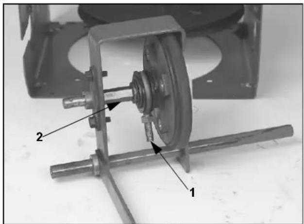 Technical diagram of a mechanical assembly with labeled parts 1 and 2, showing components like gears and shafts.