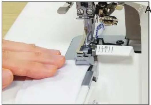 Close-up of a sewing machine needle stitching white fabric, with a hand adjusting the fabric (no visible text or symbols)