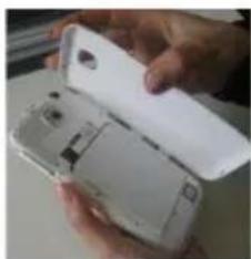 Close-up of a hand holding an open white smartphone case, showing internal components (no visible text or symbols)