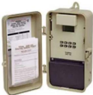 Image of a beige and purple electrical meter device with open case containing printed documents and buttons.