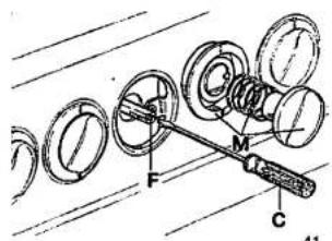 Technical diagram showing mechanical assembly with labeled parts F, M, and C