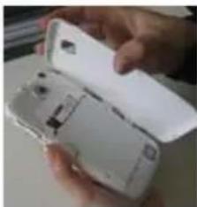 Hand holding a white plastic device with open lid (no visible text or symbols)