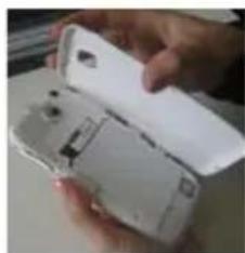 Close-up of a hand holding an open white electronic device (no visible text or symbols)