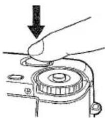 Hand pressing down on a mechanical component with a downward arrow indicating force (no text or symbols)