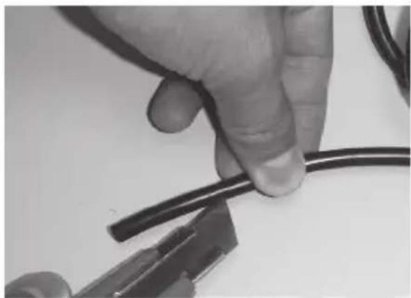 Close-up of a hand holding a black wire with pliers nearby (no text or symbols visible)