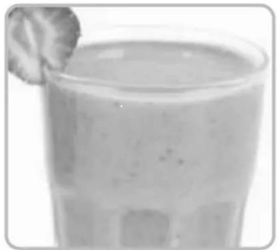 Close-up of a glass of light-colored beverage with a garnish, no visible text or symbols