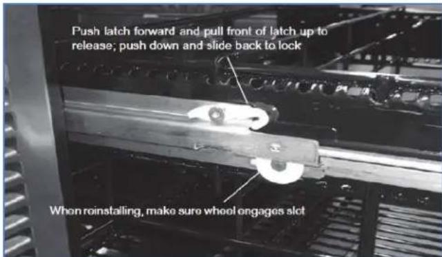 Push latch forward and pull front of latch up to release; push down and slide back to lock When reinstalling, make sure wheel engages slot