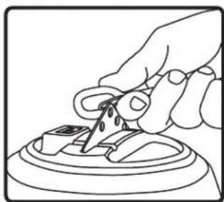 Line drawing of a hand using scissors to cut or mark a small object on a circular base (no text or symbols)