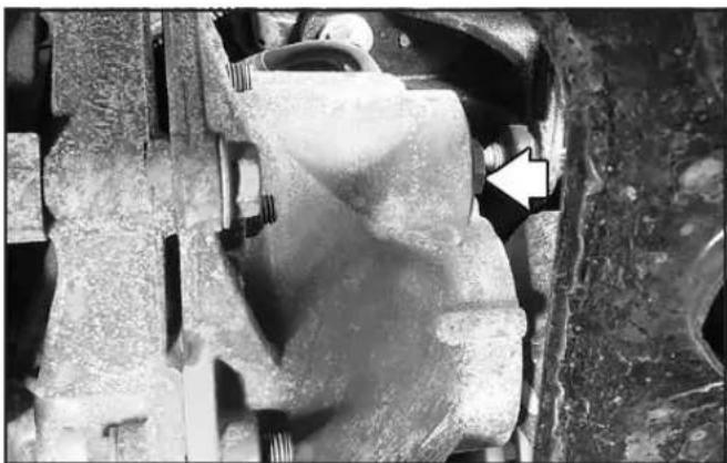 Close-up of a mechanical component with a white arrow pointing to a specific area (no visible text or symbols)