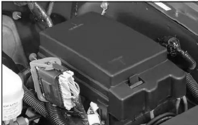 Close-up of a car's internal battery compartment with visible wiring and components (no text or symbols)