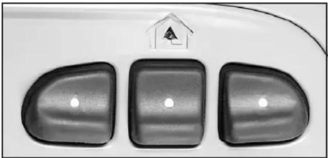 Close-up of a car's front panel with three buttons and a small house icon above (no text or symbols)