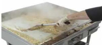Person cooking on a large griddle with visible steam and food (no text or symbols).