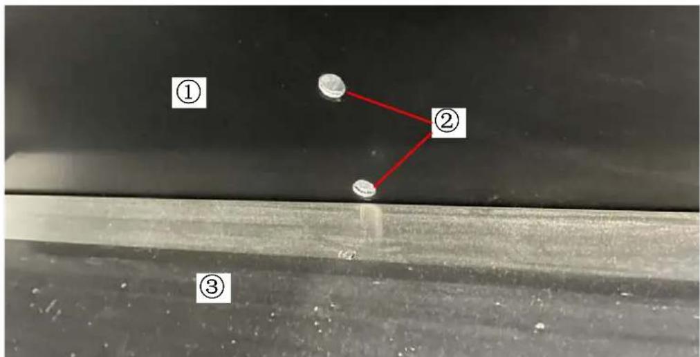 Microscopic image with numbered annotations (①, ②, ③) showing a red line connecting two circular features on a dark surface.