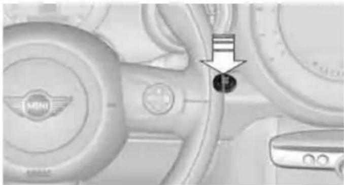 Close-up of a car dashboard with a highlighted section showing a black arrow pointing to the bottom-left corner (no visible text or symbols)