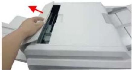 Close-up of a hand pressing down on a white paper airplane wing, with a red arrow indicating the motion (no text or symbols visible)