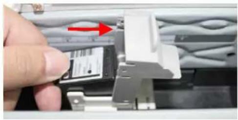 Close-up of a hand inserting a card into a device component, with a red arrow indicating direction (no text or symbols visible)