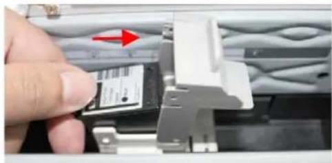 Close-up of a hand inserting a card into a mechanical component, with a red arrow indicating the direction (no visible text or symbols)