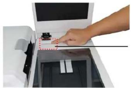 Hand inserting a small object into a device, with no visible text or symbols