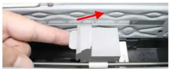 Close-up of a finger pressing a white plastic component on a metal panel (no text or symbols visible)