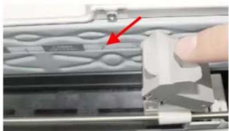 Close-up of a hand pressing a component on a mechanical device (no visible text or symbols)