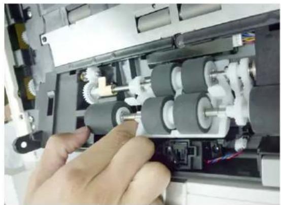 Close-up of hands assembling a mechanical device with visible gears and shafts (no text or symbols)