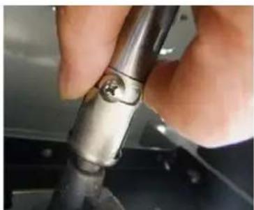 Close-up of a hand holding a metallic mechanical component with a small circular feature (no visible text or symbols)