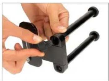 Close-up of hands holding a black mechanical clamp or bracket component (no visible text or symbols)