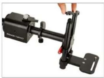 Close-up of a black mechanical device with a hand adjusting its lever (no visible text or symbols)