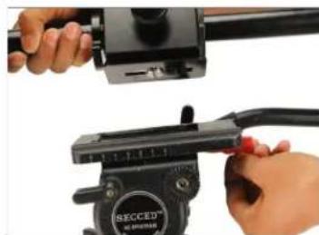 Close-up of hands adjusting a black mechanical device with a clip, no visible text or symbols