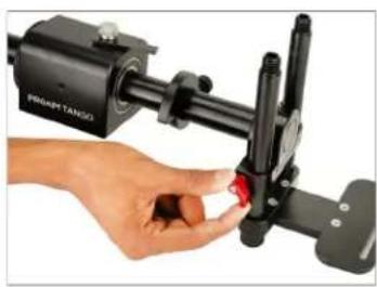 Close-up of a hand adjusting a black SmartTANGO camera lens with a red trigger (no visible text or symbols)