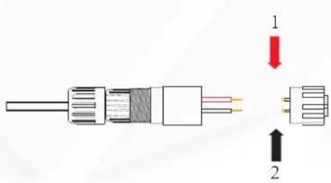 Diagram of a cable connector with labeled parts and directional arrows indicating assembly or connection.