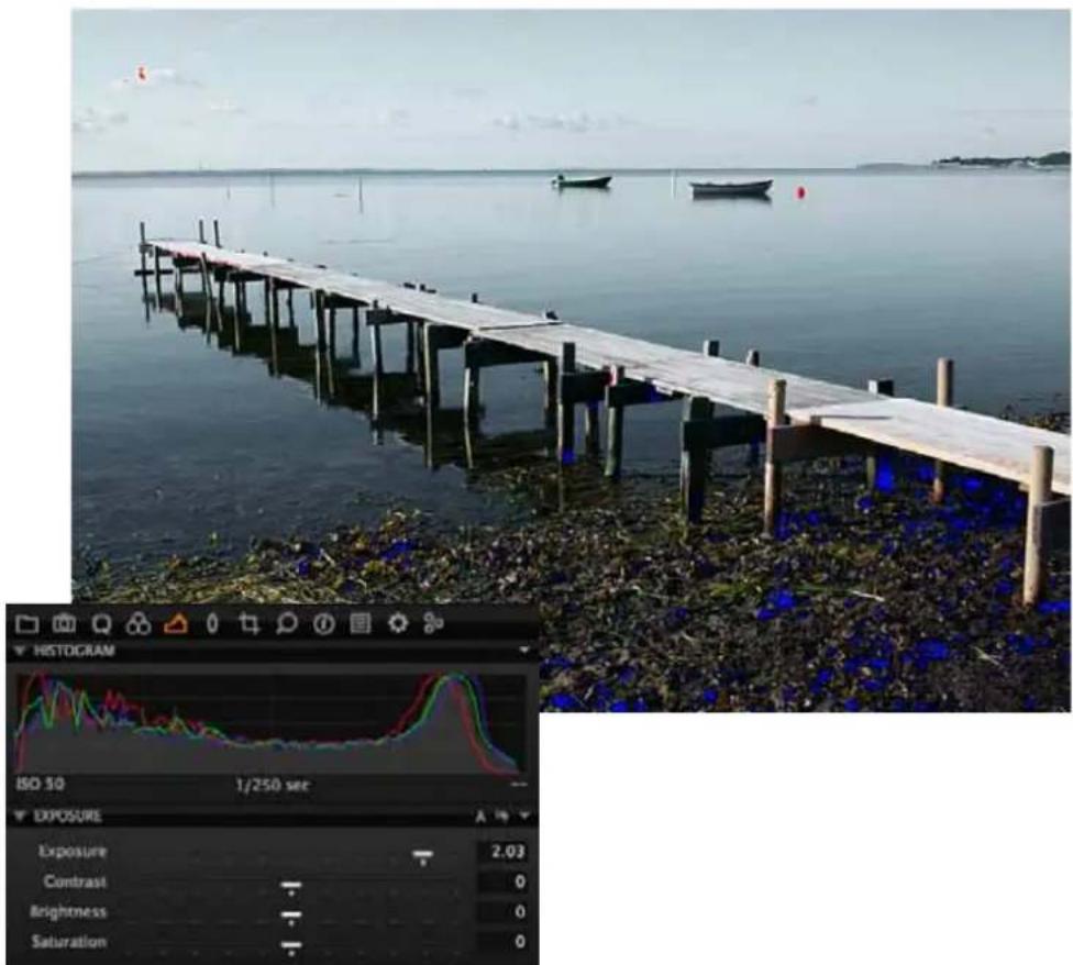 Photo of a wooden dock extending over water with boats in the background, accompanied by a HISTOGRAM-style exposure curve and adjustment panel.