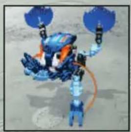 Illustration of a blue and orange robotic arm with attached propellers, standing on a sandy surface (no text or symbols)