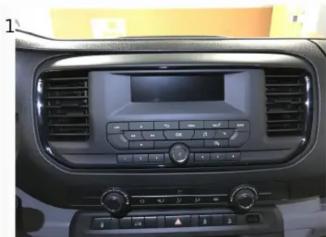Interior view of a car dashboard with air conditioner, digital display, and control knobs (no visible text or symbols)