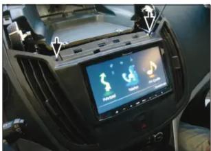 Car dashboard display showing digital interface with icons and text labels, likely for vehicle or app interface