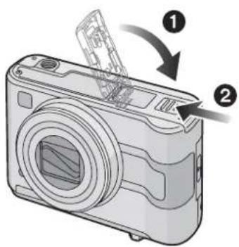 Diagram of a digital camera with numbered parts and directional arrows indicating assembly or operation