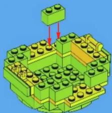 3D diagram of a green LEGO structure with yellow base and central block, no text or symbols present
