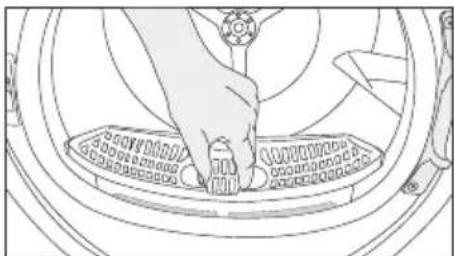 Line drawing of a hand pressing down on a circular mechanical component (no text or symbols)