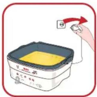 Illustration of a cooking appliance with a hand holding an electrical outlet, showing text labels and a yellow interior.