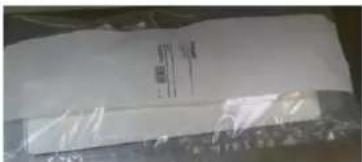 Cropped image of a white printed label with faint text and symbols, likely from a document or label.