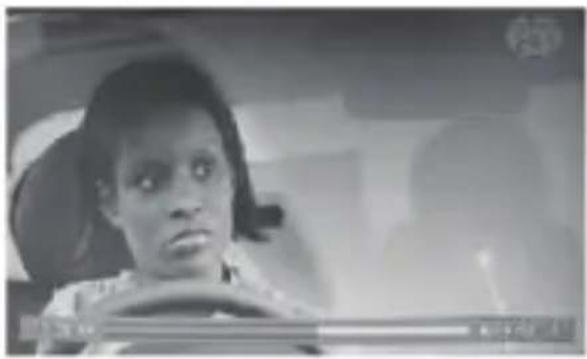 Black-and-white photo of a person in a car, with visible Chinese text overlay at bottom