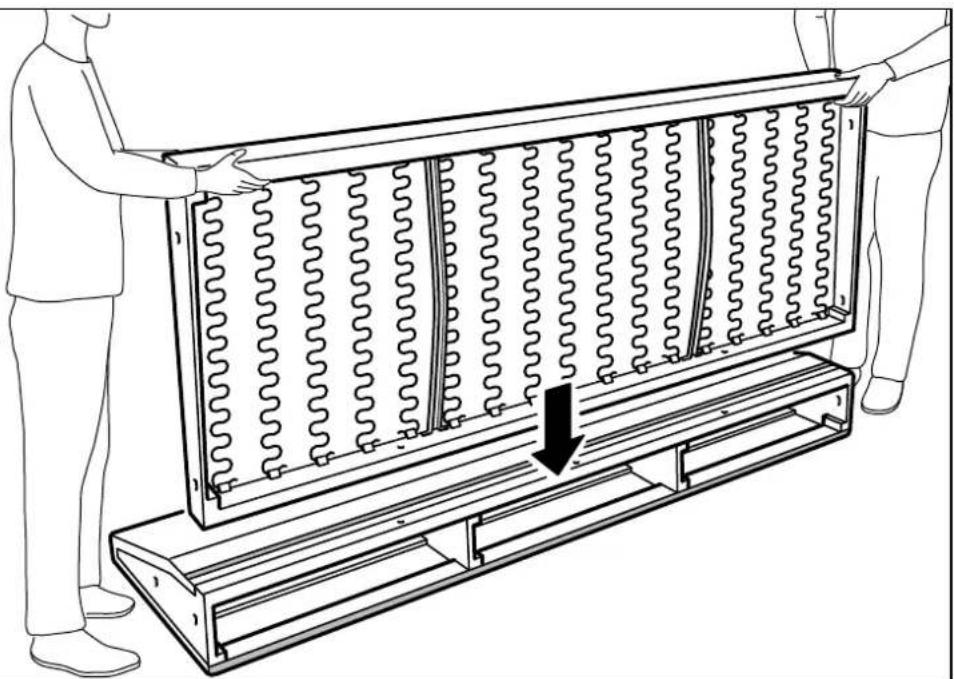 Line drawing of two people handling a coiled heating element on a metal shelf, with a black arrow indicating the process (no text or symbols present)
