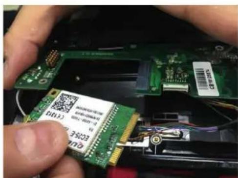 Close-up of hands holding a green electronic component with visible QR code and printed labels, likely for assembly or testing purposes.